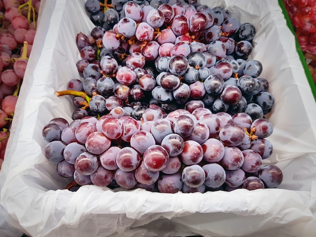 Primer plano de frutas de uva roja en una bolsa de plástico blanca