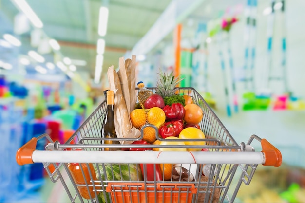 Primer plano de frutas y verduras frescas en el fondo del carrito de compras