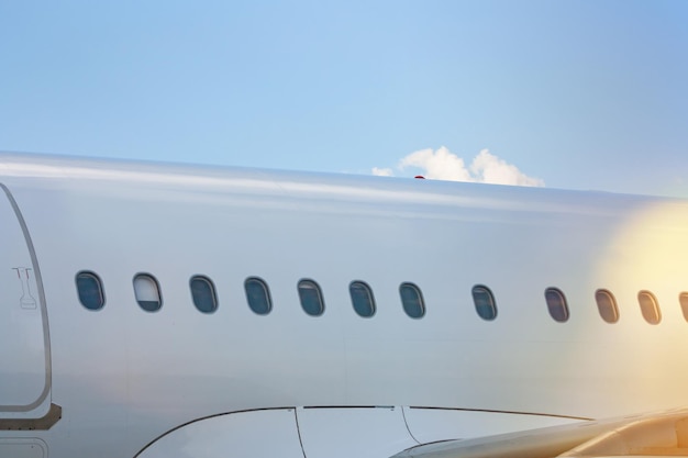 Primer plano del fuselaje de un avión de pasajeros blanco en un día claro y soleado