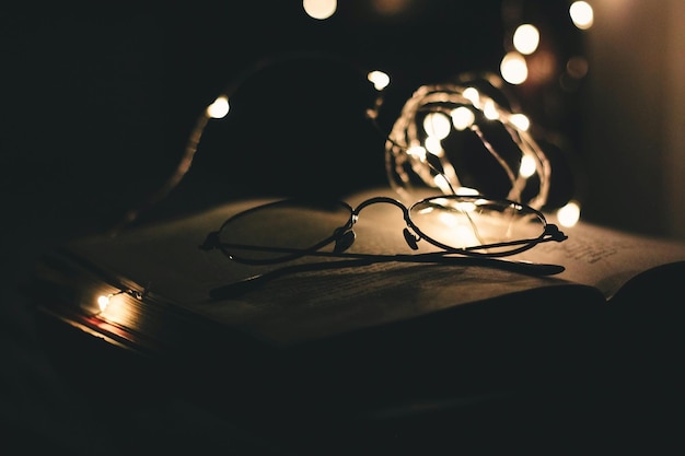 Foto primer plano de gafas en un libro abierto por luces iluminadas