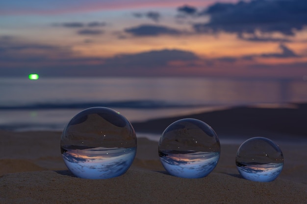 Foto primer plano de gafas en la playa contra el cielo durante la puesta de sol