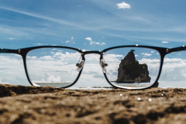 Foto primer plano de gafas de sol en la playa