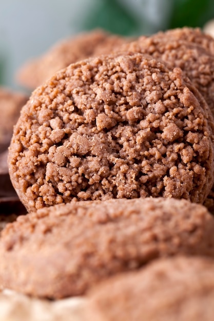 Primer plano de galletas de chocolate en una vieja mesa de cocina, primer plano de galletas de harina y cacao, postres y otros alimentos dulces