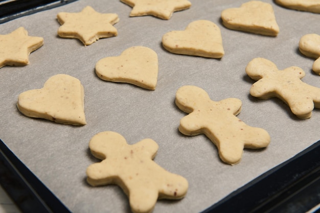 Primer plano de galletas de jengibre dispuestas sobre una rejilla de pastelería. Proceso de cocción. Preparativos navideños. 25 de diciembre, concepto de feliz Navidad