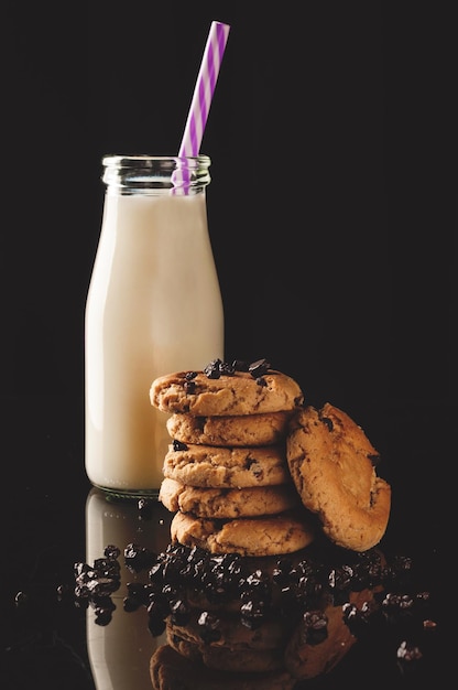 Primer plano de galletas con leche sobre un fondo negro