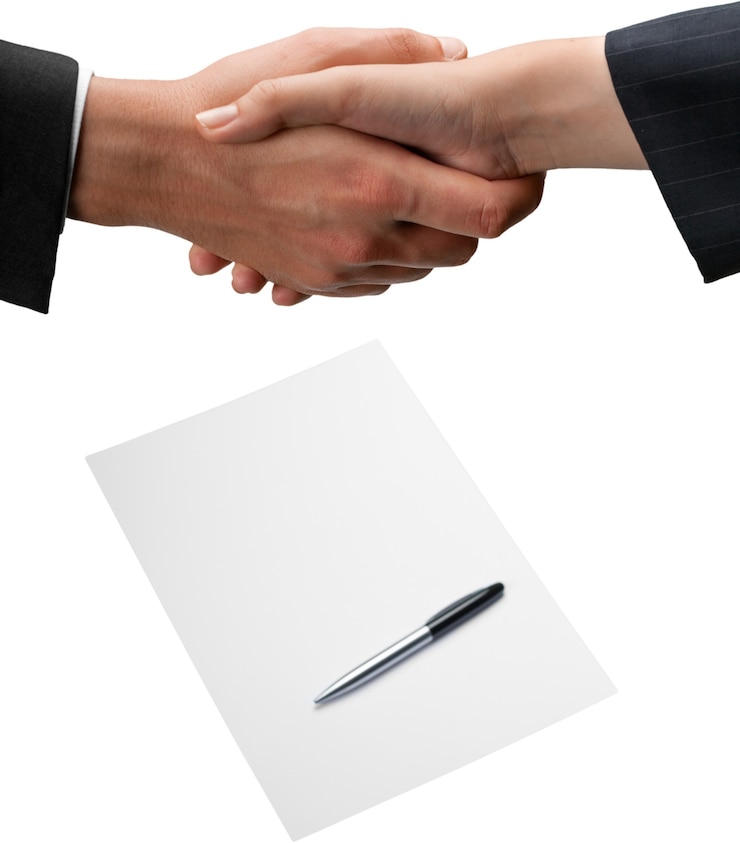 Foto primer plano de la gente de negocios un apretón de manos con contrato en segundo plano.