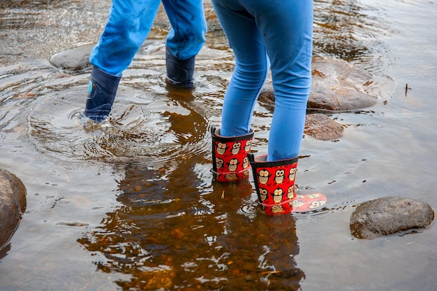 Primer plano de la gente en el río con botas de goma impermeables.