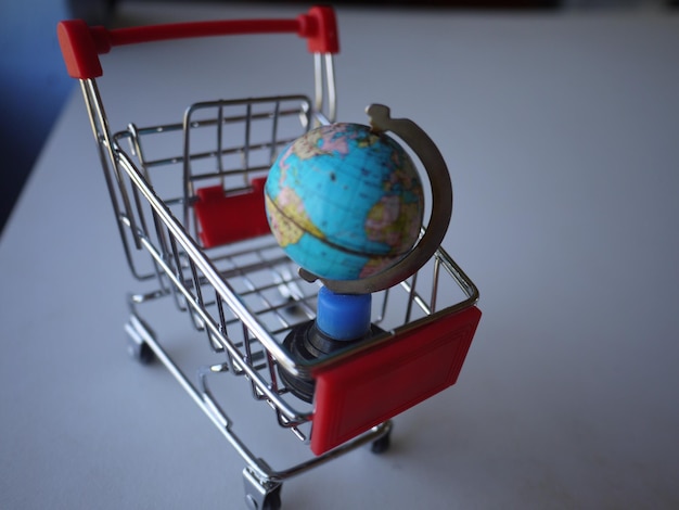 Primer plano del globo en un pequeño carrito de compras en la mesa