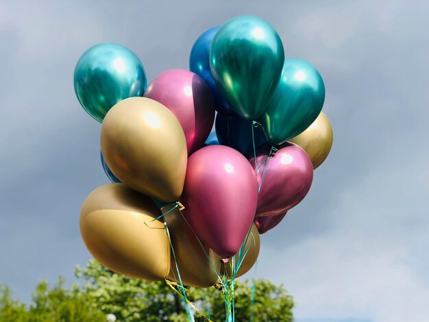 Primer plano de globos multicolores contra el cielo azul