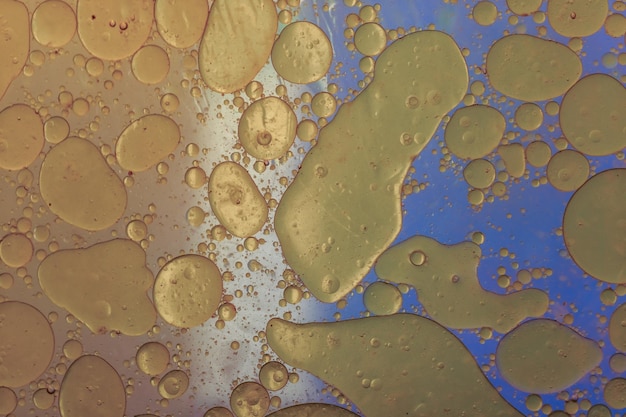 Un primer plano de gotas de aceite sobre un fondo azul.