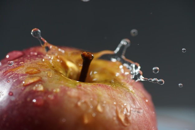 Foto primer plano de gotas de agua en una manzana contra un fondo gris