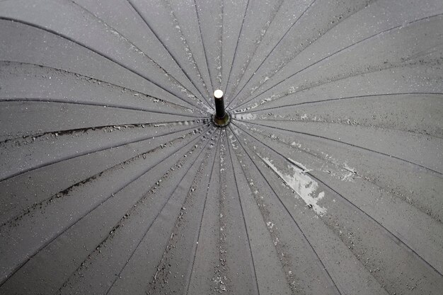 primer plano de las gotas de agua que se encuentran en el paraguas negro después de la lluvia, una pequeña profundidad de campo