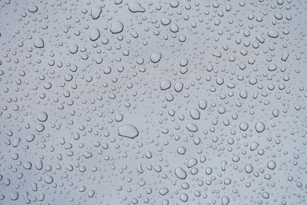 Foto primer plano de gotas de lluvia sobre fondo de textura de vidrio de ventana gris