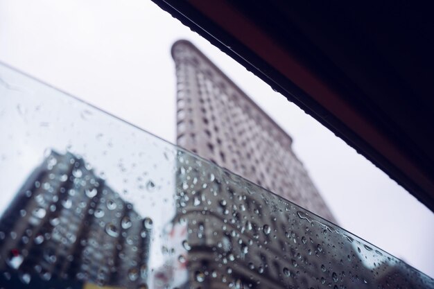 Foto primer plano de gotas de lluvia en el vidrio de la ventana contra el edificio flatiron