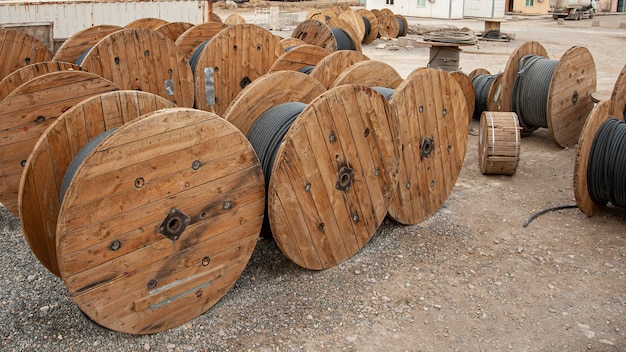 Un primer plano de grandes bobinas industriales de madera con cable en un sitio de construcción