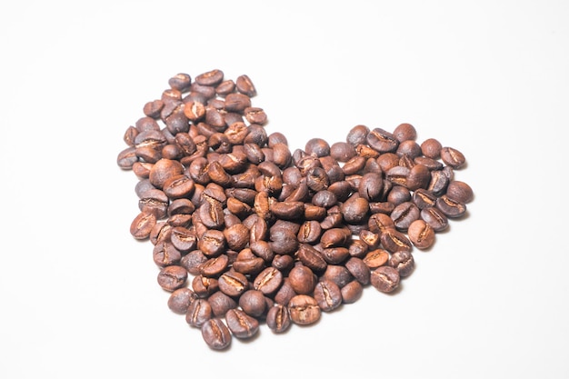 Primer plano de granos de café tostados contra un fondo blanco