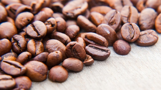 Primer plano de los granos de café tostados en la mesa