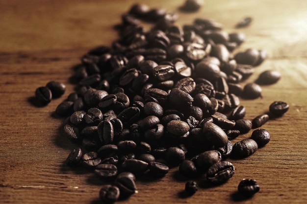Primer plano de granos de café tostados en superficie de madera