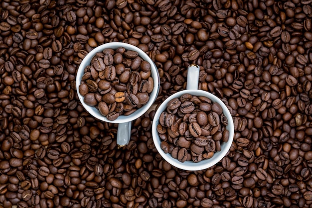Primer plano de granos de café tostados con tazas
