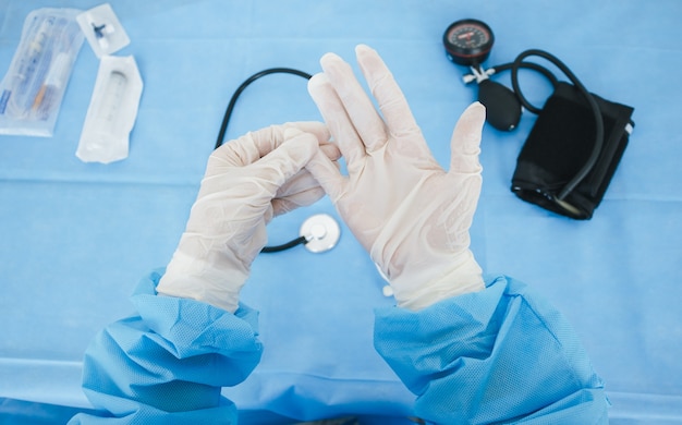 Primer plano de guantes blancos médicos en las manos del médico.