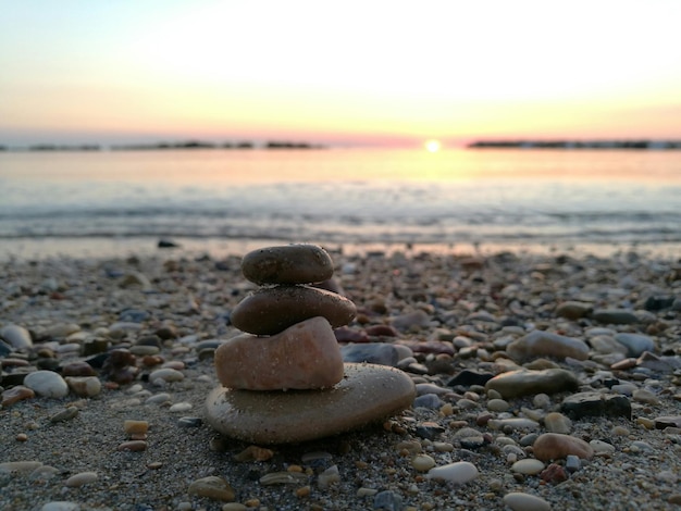 Foto primer plano de guijarros en la playa contra el cielo durante la puesta de sol