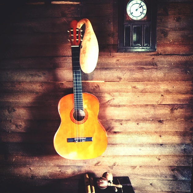 Primer plano de una guitarra colgada en la pared