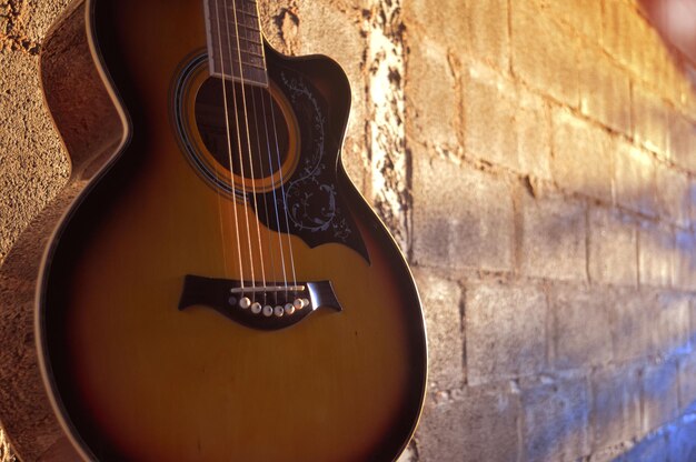 Primer plano de la guitarra contra la pared