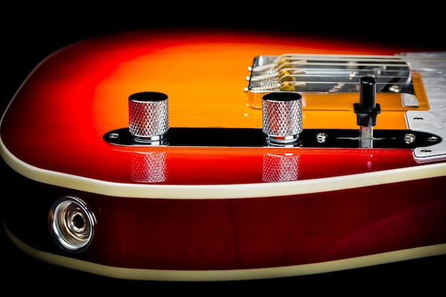 Foto primer plano de una guitarra eléctrica fender telecaster aislada en el fondo oscuro