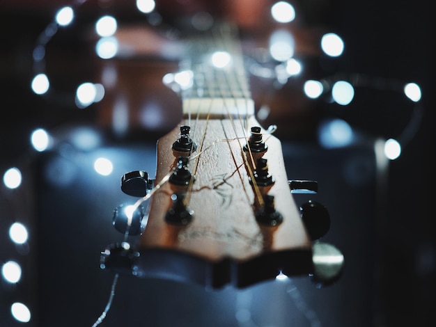 Primer plano de una guitarra con luces de cuerdas iluminadas