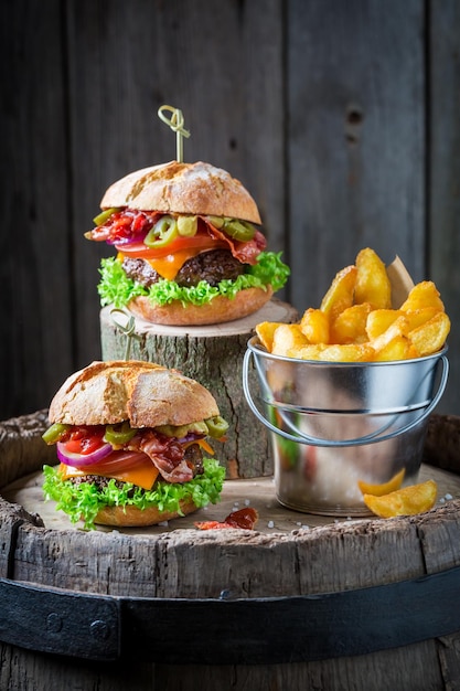 Primer plano de una hamburguesa hecha de tocino, tomate y carne de res