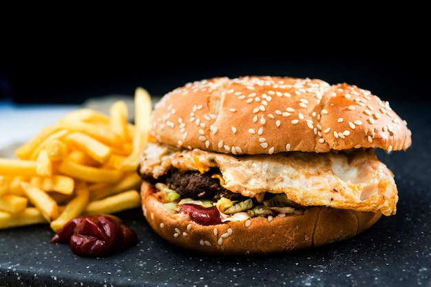 Primer plano de una hamburguesa en la mesa contra un fondo negro