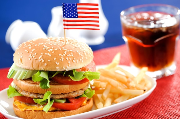 Foto primer plano de una hamburguesa y papas fritas en un plato sobre la mesa