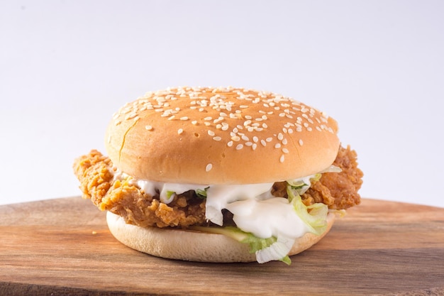 Primer plano de una hamburguesa de pollo crujiente contra un fondo blanco