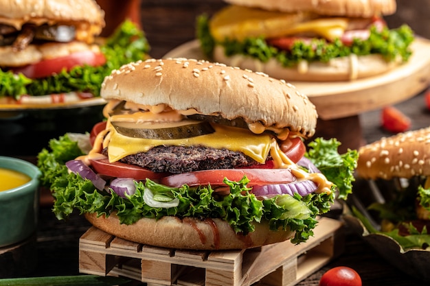 Primer plano de hamburguesas caseras sobre fondo de madera rústica. concepto de comida rápida y comida chatarra