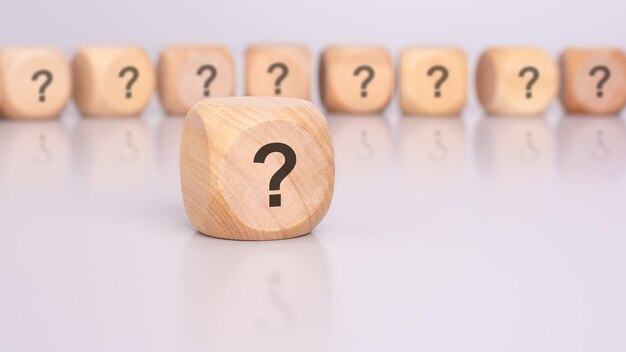 en primer plano hay un cubo de madera con un signo de interrogación
