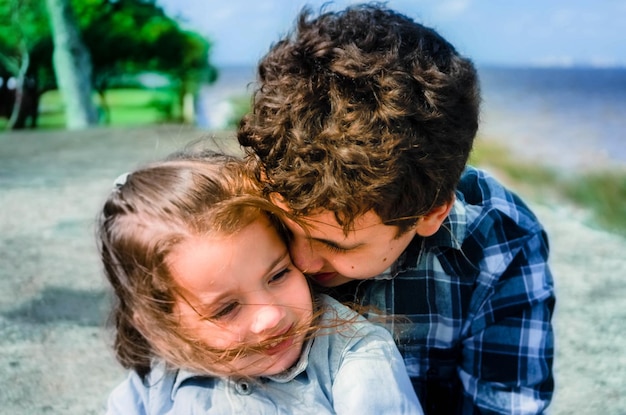 Foto primer plano de hermano y hermana abrazándose al aire libre