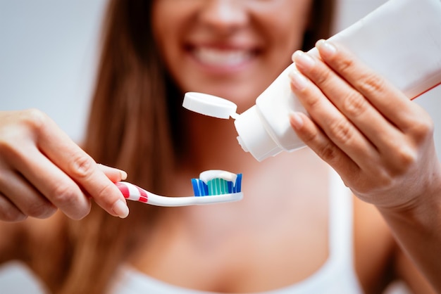 Primer plano de una hermosa joven cepillarse los dientes. Enfoque selectivo.