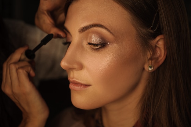 Primer plano de la hermosa joven cuyo maestro de maquillaje