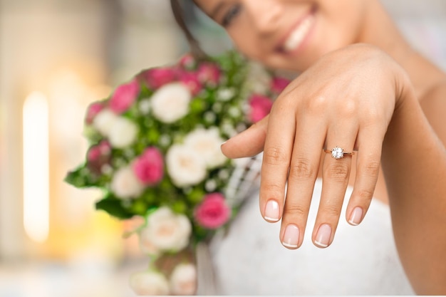 Primer plano Hermosa joven novia mostrando la mano y sosteniendo el ramo de novia