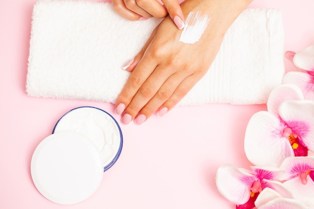 Primer plano de una hermosa mano femenina aplicando crema de manos.