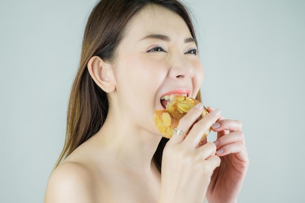Foto primer plano hermosa mujer asiática disfruta comiendo un pastel. aislado sobre fondo blanco.