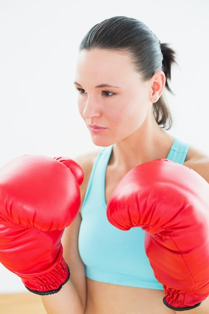 Primer plano de una hermosa mujer joven en guantes de boxeo rojos