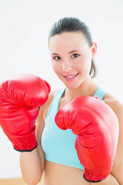 Primer plano de una hermosa mujer joven en guantes de boxeo rojos