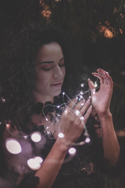 Primer plano de una hermosa mujer con luces iluminadas