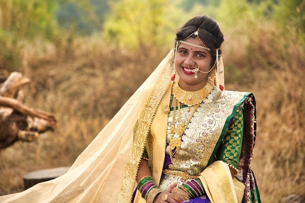 Foto un primer plano de una hermosa novia india en un sari tradicional posando al aire libre en un parque