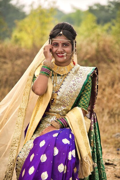 Foto un primer plano de una hermosa novia india en un sari tradicional posando al aire libre en un parque