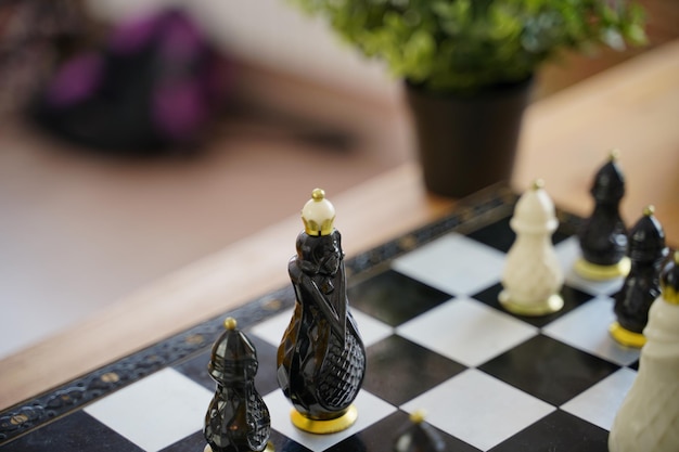 Primer plano de hermoso ajedrez en la mesa en la habitación Enfoque selectivo de piezas de ajedrez de porcelana en el tablero de ajedrez