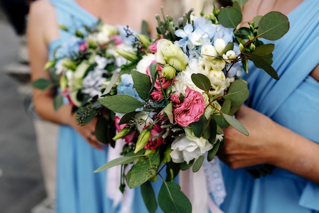 Primer plano del hermoso ramo de novia celebrada por dama de honor en vestido azul