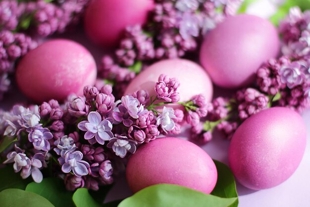 Primer plano de hermosos huevos de Pascua lila con ramas lilas florecientes. Decoración de Pascua. Enfoque selectivo.