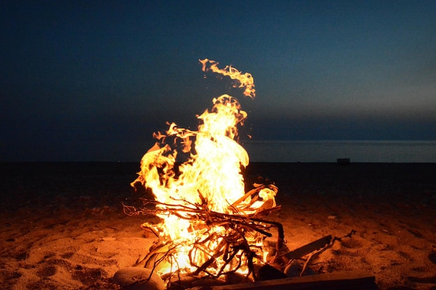 Primer plano de una hoguera en la playa por la noche